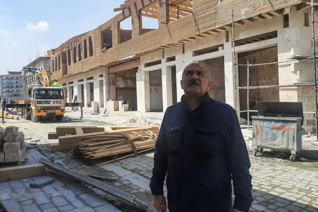 Local resident Kemal Aribas inspects intense reconstruction effort in Kurtulus Street, located in the old town of Antakya on April 1, 2026, over three years after the earthquake that devastated southeastern Turkey, including Antakya, on February 6, 2023. Nothing is "as it was before" the earthquake that devastated the ancient city and southern Turkey in February 2023, killing at least 53,000 people : Three years after the disaster, residents are denouncing opaque reconstruction plans that threaten to empty the old town and jeopardise its multicultural identity. Once bustling, adjacent to working-class neighbourhoods as well as Muslim, Christian and Jewish places of worship, Kurtulus Avenue is now a vast construction site where listed historic buildings are being hastily rebuilt, with support from the European Union. The old town of Antakya was home to more than 13,000 residents before the earthquake, but virtually no homes will remain, according to the controversial new urban development plan. (Photo by Burcin GERCEK / AFP) / TO GO WITH AFP STORY BY BURC?N GERCEK