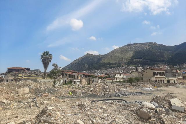 This photograph shows a general view of ruins and debris of Antakya's partly remaining old town, on April 1, 2026, over three years after the earthquake that devastated southeastern Turkey, including Antakya, on February 6, 2023. Nothing is "as it was before" the earthquake that devastated the ancient city and southern Turkey in February 2023, killing at least 53,000 people : Three years after the disaster, residents are denouncing opaque reconstruction plans that threaten to empty the old town and jeopardise its multicultural identity. Once bustling, adjacent to working-class neighbourhoods as well as Muslim, Christian and Jewish places of worship, Kurtulus Avenue is now a vast construction site where listed historic buildings are being hastily rebuilt, with support from the European Union. The old town of Antakya was home to more than 13,000 residents before the earthquake, but virtually no homes will remain, according to the controversial new urban development plan. (Photo by Burcin GERCEK / AFP) / TO GO WITH AFP STORY BY BURC?N GERCEK