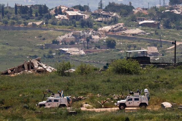 This photograph taken from the northern Israel shows a United Nations (UN) convoy driving close to destroyed houses in southern Lebanon near the border with Israel, on April 29, 2026. Lebanon's army said on April 29 that one of its soldiers was among two people killed in an Israeli strike in the country's south, the latest deadly raid despite a ceasefire in the Israel-Hezbollah war. (Photo by Jalaa MAREY / AFP)