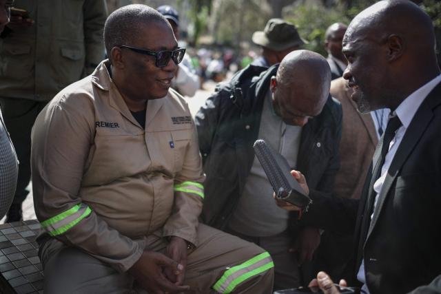 South Africa's Gauteng Province Premier Panyaza Lesufi (L) speaks with Evangelist Sipho Trevor Dlamini (R) before protesters handed him a memorandum during a protest march against undocumented migrants organised by “March and March” in Johannesburg on April 29, 2026. (Photo by EMMANUEL CROSET / AFP)