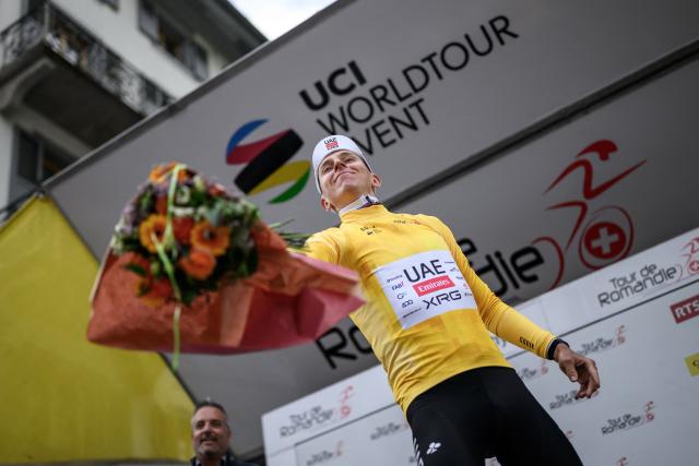 UAE Team Emirates-XRG's Slovenian rider Tadej Pogacar wearing the overall leader's yellow jersey celebrates on the podium of the first stage of the Tour of Romandie UCI cycling World tour, a 171.2 km loop from Martigny-Ville to Martigny-Ville, in Collonges, on April 29, 2026. (Photo by Fabrice COFFRINI / AFP)