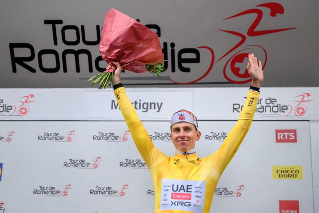 UAE Team Emirates-XRG's Slovenian rider Tadej Pogacar wearing the overall leader's yellow jersey celebrates on the podium of the first stage of the Tour of Romandie UCI cycling World tour, a 171.2 km loop from Martigny-Ville to Martigny-Ville, in Martigny, on April 29, 2026. (Photo by Fabrice COFFRINI / AFP)