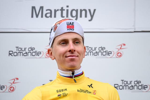 UAE Team Emirates-XRG's Slovenian rider Tadej Pogacar wearing the overall leader's yellow jersey smiles on the podium of the first stage of the Tour of Romandie UCI cycling World tour, a 171.2 km loop from Martigny-Ville to Martigny-Ville, in Martigny, on April 29, 2026. (Photo by Fabrice COFFRINI / AFP)