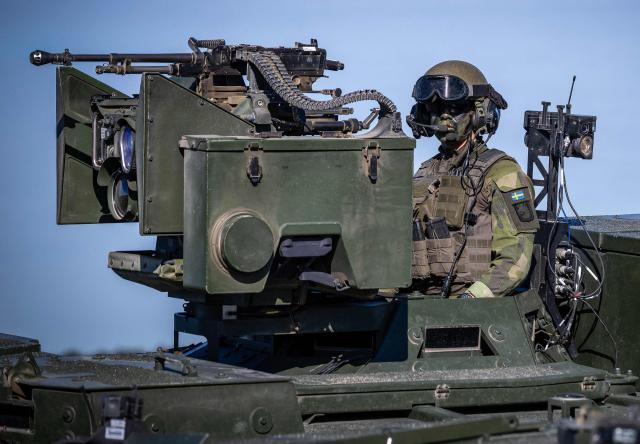 A swedish machine gunner mans his post in the turret of an Armored Terrain Vehicle 360 (Patria XA-360 AMV) as they take part in a combat display during a press day for the military exercise Aurora 26 at the Revingehed training field outside Lund in Skane, Southern Sweden on April 29, 2026. The exercise at Revingehed includes personnel from several NATO countires with the focus on lessons learned from the war in Ukraine including drones. (Photo by Johan NILSSON / various sources / AFP) / Sweden OUT