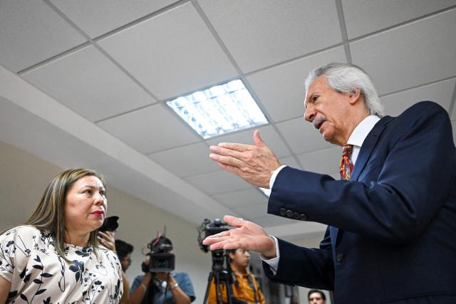 Guatemalan journalist and founder of the former newspaper 'El Periodico', Jose Ruben Zamora (R), speaks with his lawyer Roxana Lopez before starting his hearing at the Justice Palace in Guatemala City on April 29, 2026. A court hearing will decide whether Zamora should stand trial in a second case against him. (Photo by Johan ORDONEZ / AFP)