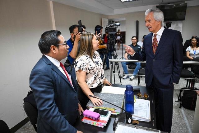 Guatemalan journalist and founder of the former newspaper 'El Periodico', Jose Ruben Zamora speaks with his lawyers Roxana Lopez (C) and Edgar Jeronimo (L) before starting his hearing at the Justice Palace in Guatemala City on April 29, 2026. A court hearing will decide whether Zamora should stand trial in a second case against him. (Photo by Johan ORDONEZ / AFP)