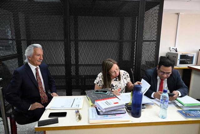 Guatemalan journalist and founder of the former newspaper 'El Periodico', Jose Ruben Zamora (L), reacts next to his lawyers Roxana Lopez (C) and Edgar Jeronimo before starting his hearing at the Justice Palace in Guatemala City on April 29, 2026. A court hearing will decide whether Zamora should stand trial in a second case against him. (Photo by Johan ORDONEZ / AFP)