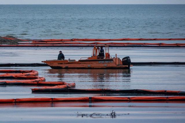 Workers set up barriers to prevent petroleum products from flowing into the Black Sea from the river following a spill caused by a recent drone attack on the Tuapse oil refinery in Tuapse, Krasnodar region on April 29, 2026, amid the ongoing Russian-Ukrainian conflict. (Photo by AFP)