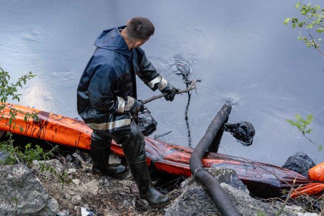 A worker cleans the river of petroleum products following a spill caused by a recent drone attack on the Tuapse oil refinery in Tuapse, Krasnodar region on April 29, 2026, amid the ongoing Russian-Ukrainian conflict. (Photo by AFP)