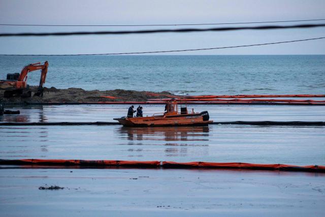 Workers set up barriers to prevent petroleum products from flowing into the Black Sea from the river following a spill caused by a recent drone attack on the Tuapse oil refinery in Tuapse, Krasnodar region on April 29, 2026, amid the ongoing Russian-Ukrainian conflict. (Photo by AFP)