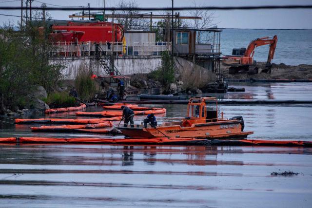 Workers set up barriers to prevent petroleum products from flowing into the Black Sea from the river following a spill caused by a recent drone attack on the Tuapse oil refinery in Tuapse, Krasnodar region on April 29, 2026, amid the ongoing Russian-Ukrainian conflict. (Photo by AFP)