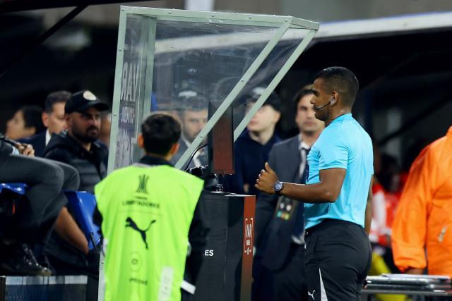 Venezuelan referee Alexis Herrera checks the VAR monitor to reverse a red card during the Copa Libertadores group stage football match between Argentina's Platense and Colombia's Independiente Santa Fe at the Ciudad de Vicente Lopez stadium in Vicente Lopez, Buenos Aires province, Argentina on April 29, 2026. (Photo by Alejandro PAGNI / AFP)