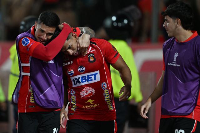 Caracas' defender #13 Jesus Yendis celebrates with teammates after scoring his team's first goal during the Copa Sudamericana group stage football match between Venezuela's Caracas FC and Argentina's Racing Club at the Olimpico de la UCV stadium in Caracas on April 29, 2026. (Photo by Juan BARRETO / AFP)