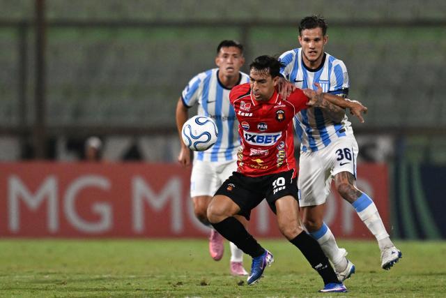 Caracas' midfielder #10 Michael Covea and Racing's midfielder #36 Bruno Zuculini fight for the ball during the Copa Sudamericana group stage football match between Venezuela's Caracas FC and Argentina's Racing Club at the Olimpico de la UCV stadium in Caracas on April 29, 2026. (Photo by Juan BARRETO / AFP)