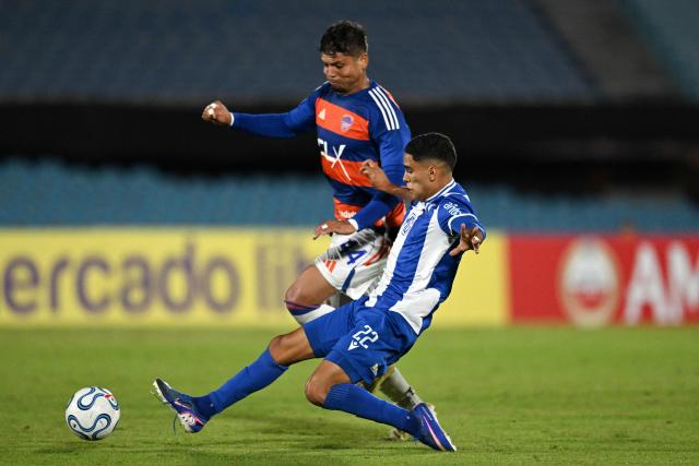 Puerto Cabello's defender #44 Geremias Melendez and Juventud's midfielder #22 Rodrigo Chagas fight for the ball during the Copa Sudamericana group stage football match between Uruguay's Juventud and Venezuela's Academia Puerto Cabello at the Centenario stadium in Montevideo on April 29, 2026. (Photo by Eitan ABRAMOVICH / AFP)