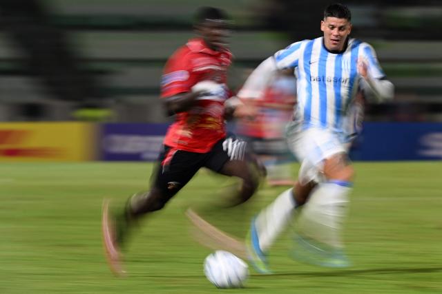 This slow shutter speed image shows Caracas' Colombian forward #27 Sebastian Gonzalez and Racing's defender #06 Marcos Rojo during the Copa Sudamericana group stage football match between Venezuela's Caracas FC and Argentina's Racing Club at the Olimpico de la UCV stadium in Caracas on April 29, 2026. (Photo by Juan BARRETO / AFP)