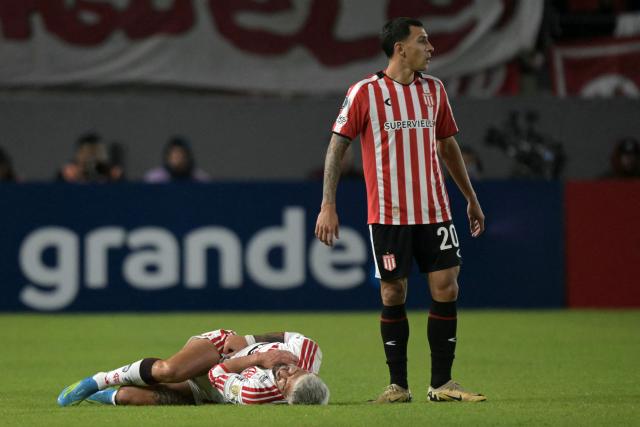 Flamengo's Uruguayan midfielder #10 Giorgian de Arrascaeta (L) grimaces in pain next to Estudiantes' defender #20 Eric Meza during the Copa Libertadores group stage football match between Argentina's Estudiantes de La Plata and Brazil's Flamengo at the Jorge Luis Hirschi stadium in La Plata, Buenos Aires province, Argentina on April 29, 2026. (Photo by JUAN MABROMATA / AFP)