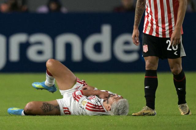 Flamengo's Uruguayan midfielder #10 Giorgian de Arrascaeta grimaces in pain next to Estudiantes' defender #20 Eric Meza during the Copa Libertadores group stage football match between Argentina's Estudiantes de La Plata and Brazil's Flamengo at the Jorge Luis Hirschi stadium in La Plata, Buenos Aires province, Argentina on April 29, 2026. (Photo by JUAN MABROMATA / AFP)