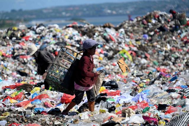 A man collects waste at the Suwung landfill in Denpasar, on Indonesia's resort island of Bali on April 17, 2026. Bali's largest landfill was declared off-limits for organic waste from the beginning of April, as the government moves to enforce a longstanding ban on open tips. (Photo by SONNY TUMBELAKA / AFP) / To go with AFP story  Indonesia-environment-waste-Bali, FOCUS by Diajeng Vayantri Dewi in Denpasar with Marchio Gorbiano in Jakarta