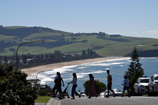 This picture taken on April 27, 2026 shows tourists visiting a street in Gerringong, about a two-hour drive south of Sydney. Viral posts of an Australian street dubbed the country's "most beautiful" have enticed coachloads of visitors to a picturesque seaside town -- and locals have had enough of it. (Photo by Saeed KHAN / AFP) / To go with AFP story Australia-tourism-internet by Oliver Hotham