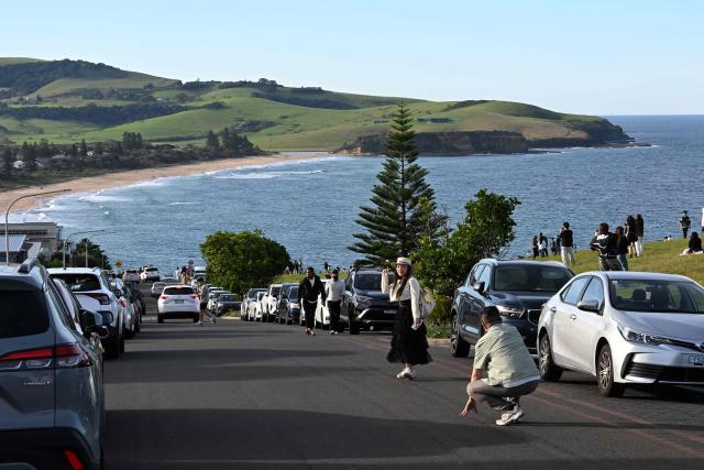 This picture taken on April 27, 2026 shows tourists visiting a street in Gerringong, about a two-hour drive south of Sydney. Viral posts of an Australian street dubbed the country's "most beautiful" have enticed coachloads of visitors to a picturesque seaside town -- and locals have had enough of it. (Photo by Saeed KHAN / AFP) / To go with AFP story Australia-tourism-internet by Oliver Hotham