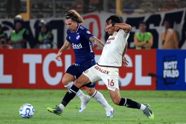 Nacional's midfielder #06 Luciano Boggio and Universitario's Argentine midfielder #16 Martin Perez fight for the ball during the Copa Libertadores group stage football match between Peru's Universitario and Uruguay's Nacional at the Monumental "U" Marathon stadium in Lima on April 29, 2026. (Photo by Connie FRANCE / AFP)