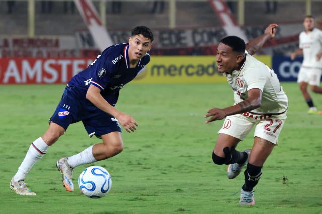Nacional's midfielder #30 Baltasar Barcia and Universitario's Ecuadorian midfielder #27 Jose Carabali fight for the ball during the Copa Libertadores group stage football match between Peru's Universitario and Uruguay's Nacional at the Monumental "U" Marathon stadium in Lima on April 29, 2026. (Photo by Connie FRANCE / AFP)