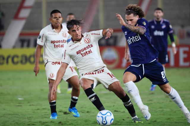 Universitario's Argentine midfielder #16 Martin Perez and Nacional's midfielder #06 Luciano Boggio fight for the ball during the Copa Libertadores group stage football match between Peru's Universitario and Uruguay's Nacional at the Monumental "U" Marathon stadium in Lima on April 29, 2026. (Photo by Connie FRANCE / AFP)