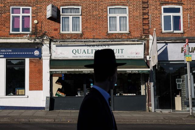A member of the local community walks past the scene (across street) where a man was stabbed the day before, in the Golders Green neighbourhood of north London, on April 30, 2026. Two Jewish men were wounded in stabbings in north London on April 29, investigated by police in the British capital as a "terrorist incident", after a series of antisemitic attacks in recent weeks. (Photo by CARLOS JASSO / AFP)