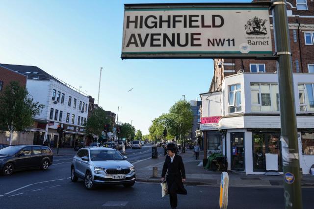 A member of the local community walks across the street near where a man was stabbed the day before, in the Golders Green neighbourhood of north London, on April 30, 2026. Two Jewish men were wounded in stabbings in north London on April 29, investigated by police in the British capital as a "terrorist incident", after a series of antisemitic attacks in recent weeks. (Photo by CARLOS JASSO / AFP)