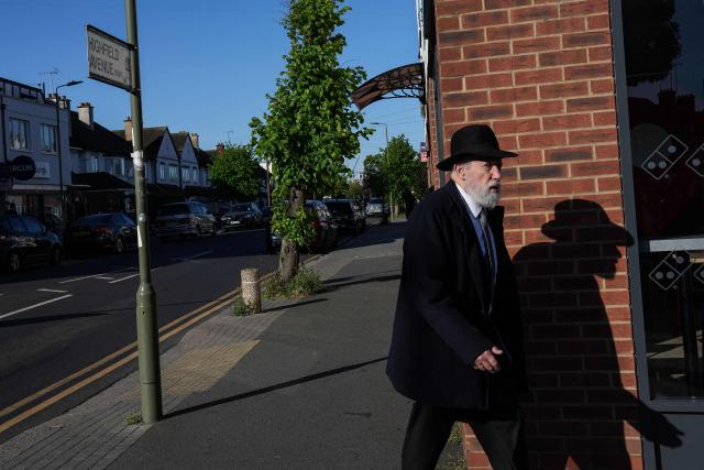 A member of the local community walks across the street from where a man was stabbed the day before, in the Golders Green neighbourhood of north London, on April 30, 2026. Two Jewish men were wounded in stabbings in north London on April 29, investigated by police in the British capital as a "terrorist incident", after a series of antisemitic attacks in recent weeks. (Photo by CARLOS JASSO / AFP)