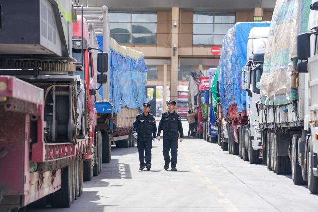 Officials inspect trucks at the Erenhot Highway Port Logistics Park, the largest land port on the border between China and Mongolia, in Erenhot in China’s northern Inner Mongolia region on April 30, 2026. (Photo by CN-STR / AFP) / China OUT