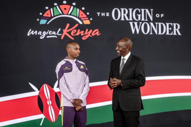 Kenya's President William Ruto (R) congratulates Kenyan marathon runner Sebastian Sawe (L) on stage during a ceremony at State House in Nairobi, on April 30, 2026, after breaking a historic world record at the London Marathon. Sebastian Sawe became the first man to run under two hours for a marathon in race conditions thanks to extraordinary talent, a punishing training regime, and the lightest shoes in history. In London on April 26, 2026, the 31-year-old Kenyan achieved one of sport's milestones, ranking alongside Roger Bannister's first sub-four minute mile in 1954. (Photo by Luis TATO / AFP)