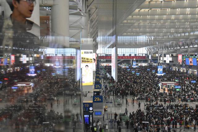 Passengers prepare to board trains at Shanghai Hongqiao Railway Station in Shanghai on April 30, 2026, ahead of the Labour Day holiday which starts on May 1. (Photo by JADE GAO / AFP)