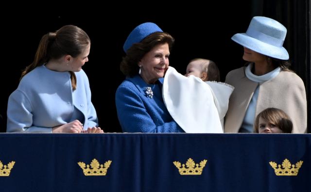 Queen Silvia of Sweden (2nd L) holds Princess Ines Marie Lilian Silvia in her arms as Princess Sofia of Sweden (R) and Princess Estelle of Sweden (L) look on, standing on the balcony to watch the changing of the guard as members of the Swedish Armed Forces pay tribute to the King at the Outer Courtyard of the Royal Palace in Stockholm, Sweden, on April 30, 2026, during celebrations to mark the 80th birthday of Sweden's King Carl XVI Gustaf. (Photo by Jonathan Nackstrand / AFP)