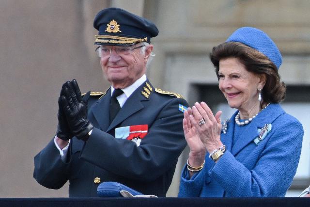 Sweden's King Carl XVI Gustaf (L) and Sweden's Queen Silva applaud from the balcony as members of the Swedish Armed Forces pay tribute to the King at the Outer Courtyard of the Royal Palace in Stockholm, Sweden, on April 30, 2026, during celebrations to mark the 80th birthday of Sweden's King Carl XVI Gustaf. (Photo by Jonathan Nackstrand / AFP)
