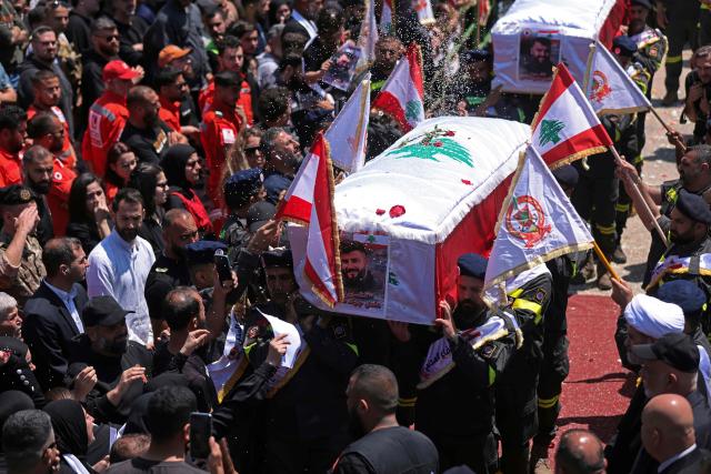 Mourners carry the coffins of three Lebanese Civil Defense members who were killed in an Israeli airstrike on the town of Majdal Zoun, during their funeral in the southern city of Tyre on April 30, 2026. The Lebanese health ministry said Israeli strikes on April 28 killed eight people, including civil defence rescuers, and wounded two soldiers in the country's south, despite a fragile ceasefire. (Photo by MAHMOUD ZAYYAT / AFP)