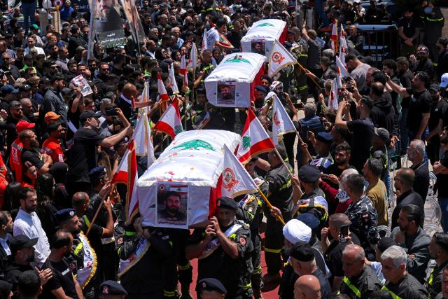 Mourners carry the coffins of three Lebanese Civil Defense members who were killed in an Israeli airstrike on the town of Majdal Zoun, during their funeral in the southern city of Tyre on April 30, 2026. The Lebanese health ministry said Israeli strikes on April 28 killed eight people, including civil defence rescuers, and wounded two soldiers in the country's south, despite a fragile ceasefire. (Photo by MAHMOUD ZAYYAT / AFP)