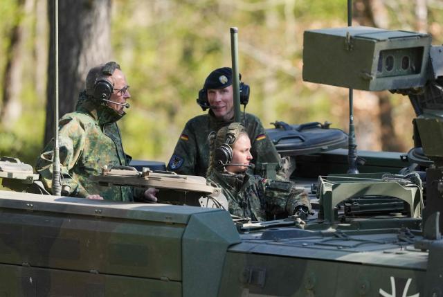 German Chancellor Friedrich Merz (L) and the Inspector of the Army Christian Freuding (C) are driven in a GTK Boxer tank at the German army barracks in Munster, northern Germany, on April 30, 2026, as they visit the troops of the German Army. (Photo by Markus Schreiber / POOL / AFP)