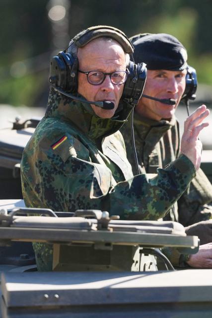 German Chancellor Friedrich Merz (L) and the Inspector of the Army Christian Freuding are sitting in a GTK Boxer tank at the German army barracks in Munster, northern Germany, on April 30, 2026, as they visit the troops of the German Army. (Photo by Markus Schreiber / POOL / AFP)