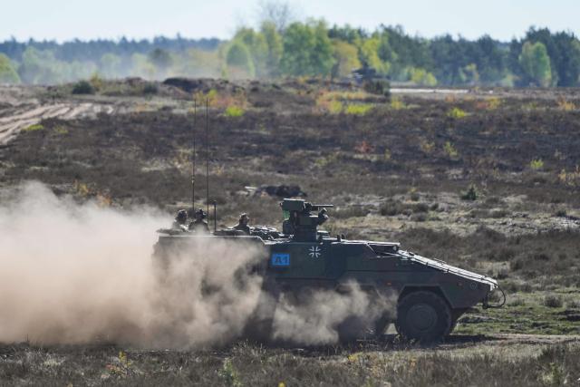 German Chancellor Friedrich Merz (L) and the Inspector of the Army Christian Freuding (C) are driven in a GTK Boxer tank at the German army barracks in Munster, northern Germany, on April 30, 2026, as they visit the troops of the German Army. (Photo by Markus Schreiber / POOL / AFP)