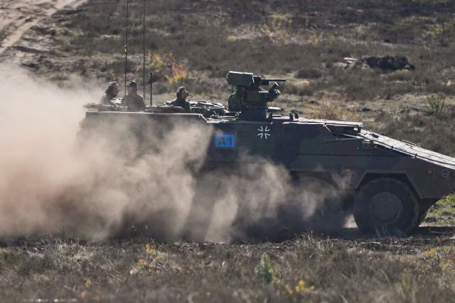 German Chancellor Friedrich Merz (L) and the Inspector of the Army Christian Freuding (C) are driven in a GTK Boxer tank at the German army barracks in Munster, northern Germany, on April 30, 2026, as they visit the troops of the German Army. (Photo by Markus Schreiber / POOL / AFP)