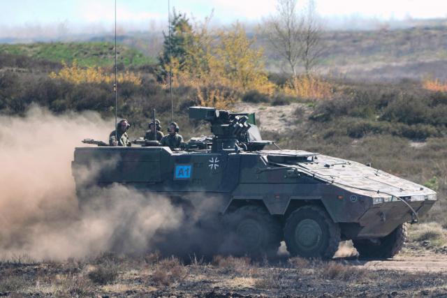 German Chancellor Friedrich Merz (L) and the Inspector of the Army Christian Freuding (C) are driven in a GTK Boxer tank at the German army barracks in Munster, northern Germany, on April 30, 2026, as they visit the troops of the German Army. (Photo by Markus Schreiber / POOL / AFP)