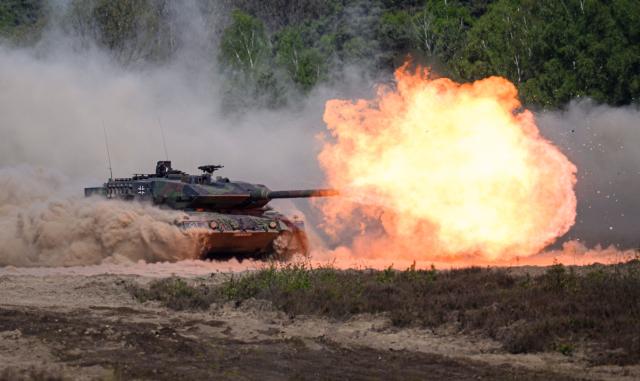 TOPSHOT - A Leopard 2A6 tank fires during a demonstration for the German Chancellor visiting the troops of the German Army (Bundeswehr) at the German armed forces' barracks in Munster, northern Germany, on April 30, 2026. (Photo by DANIEL REINHARDT / AFP)