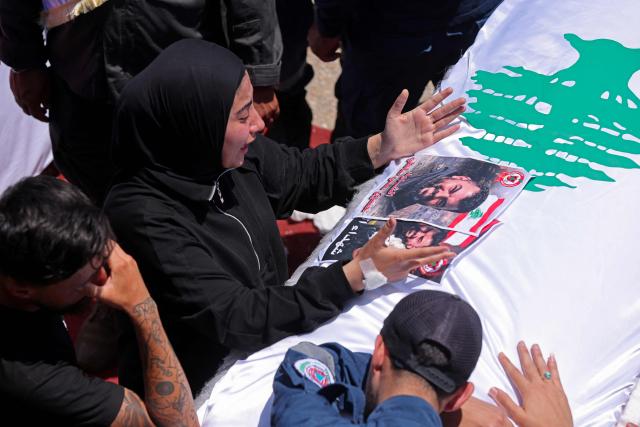 Mourners cry over a coffin during the funeral of three Lebanese Civil Defense members who were killed in an Israeli airstrike, in the southern city of Tyre on April 30, 2026. The Lebanese health ministry said Israeli strikes on April 28 killed eight people, including civil defence rescuers, and wounded two soldiers in the country's south, despite a fragile ceasefire. (Photo by MAHMOUD ZAYYAT / AFP)
