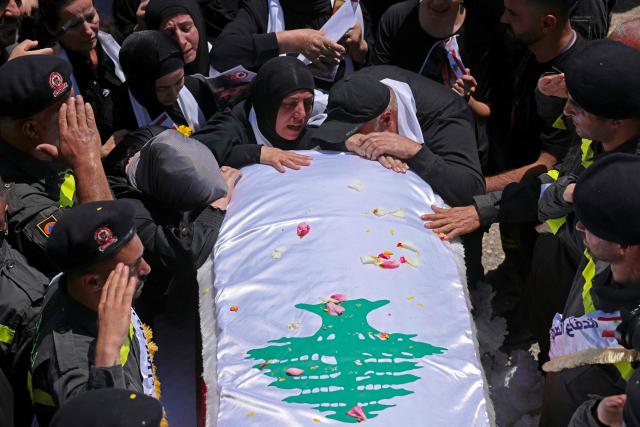 Mourners cry over a coffin during the funeral of three Lebanese Civil Defense members who were killed in an Israeli airstrike, in the southern city of Tyre on April 30, 2026. The Lebanese health ministry said Israeli strikes on April 28 killed eight people, including civil defence rescuers, and wounded two soldiers in the country's south, despite a fragile ceasefire. (Photo by MAHMOUD ZAYYAT / AFP)