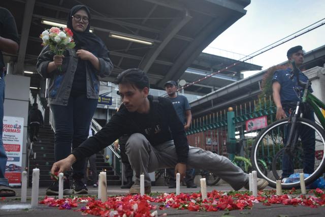 People take part in a flower-strewing ceremony to pray for the victims of a train collision, at Bekasi Timur Station in Bekasi, West Java, on April 30, 2026. The death toll from a train crash outside the Indonesian capital Jakarta rose to 16, all women, after an injured passenger passed away in hospital, officials said April 29. (Photo by Rezas / AFP)