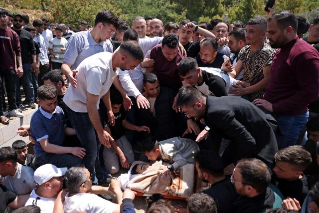 Mourners carry the body of 16-year-old Palestinian Ibraheem Khayyat, who was killed in an Israeli raid, during his funeral in the occupied West Bank city of Hebron on April 30, 2026. (Photo by HAZEM BADER / AFP)