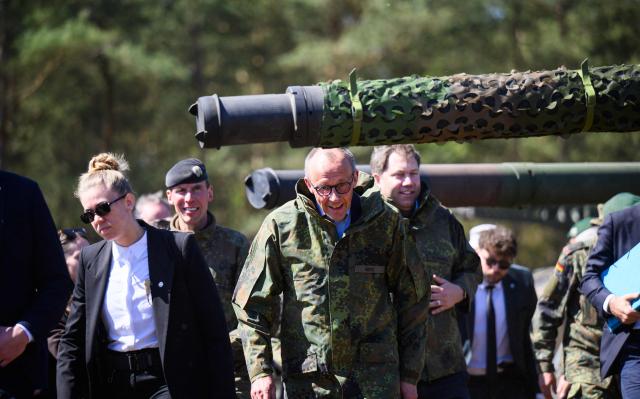 German Chancellor Friedrich Merz (C), German Finance Minister and Vice Chancellor Lars Klingbeil (R) are accompanied by the Inspector of the Army Christian Freuding (2nd L) during their visit to the German army barracks in Munster, northern Germany, on April 30, 2026. (Photo by DANIEL REINHARDT / AFP)