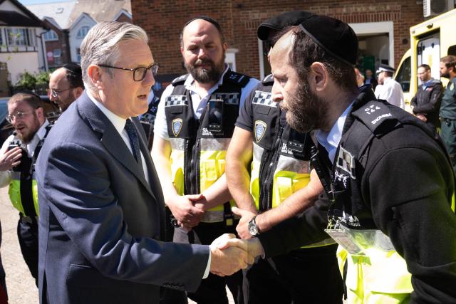 Britain's Prime Minister Keir Starmer (L) meets first responders from Shomrim North West London during a visit to Golders Green in north-west London on April 30, 2026, the day after two men were stabbed. Two Jewish men were wounded in stabbings in north London on April 29, investigated by police in the British capital as a "terrorist incident", after a series of antisemitic attacks in recent weeks. (Photo by Stefan Rousseau / POOL / AFP)